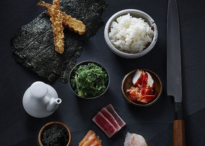 Ingredients for sushi on a black ceramic
