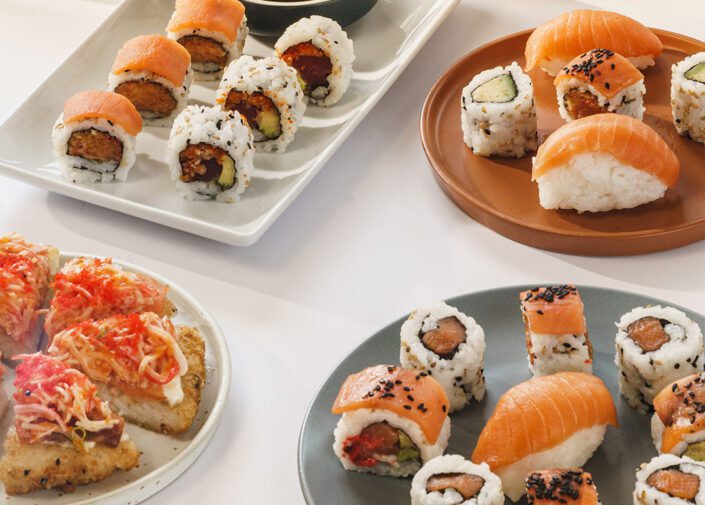 Three persons sharing plates of sushis