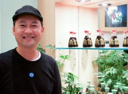 Sushi Shop franchisee smiling in front of the shelves
