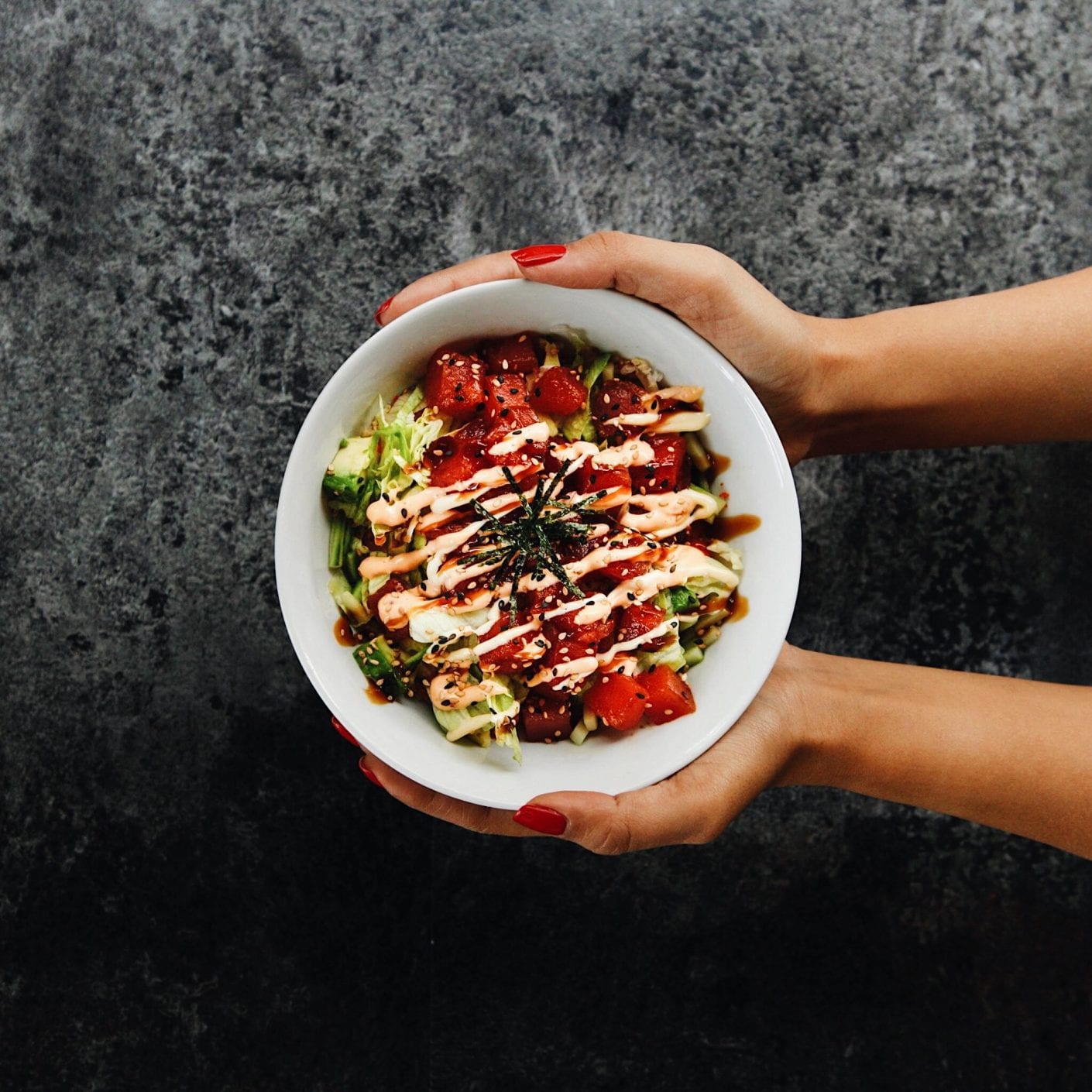 Hand holding a Sushi Shop's Tuna Poke Bowl